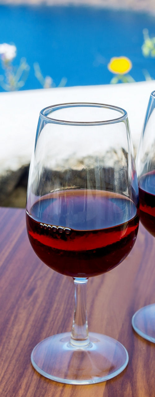 Wine glasses overlooking coastal scenery