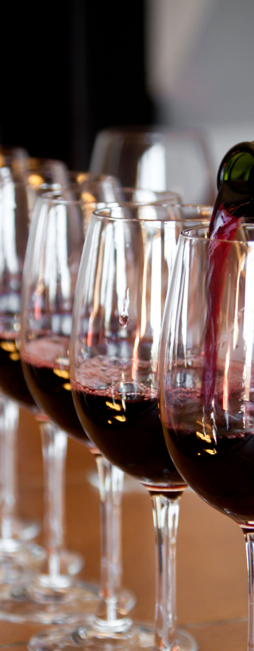 Red wine poured into multiple glasses