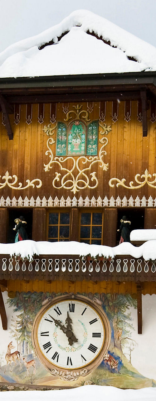 Snow-covered chalet with large decorative clock