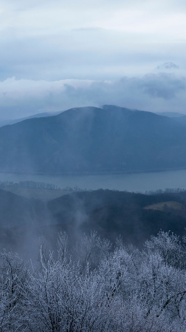 Winter river bend with misty mountains