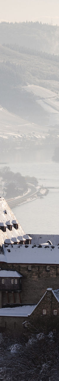 Snow-covered castle overlooking a river valley