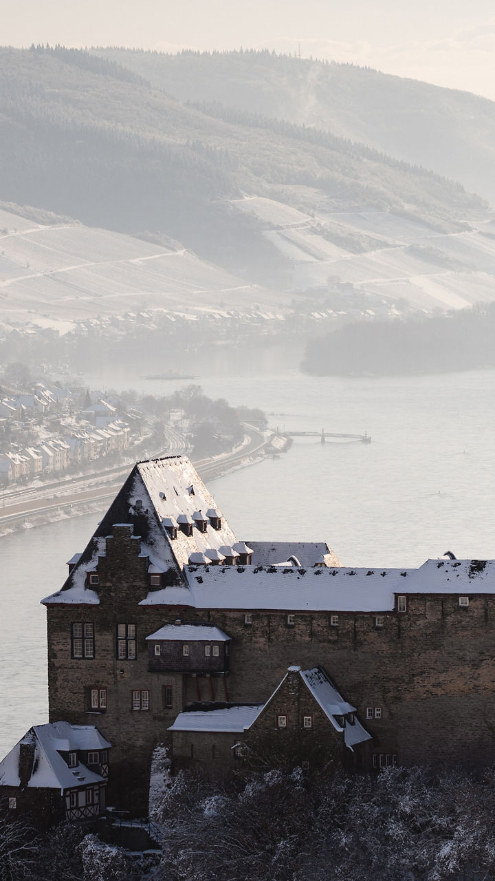 Snow-covered castle overlooking a river valley