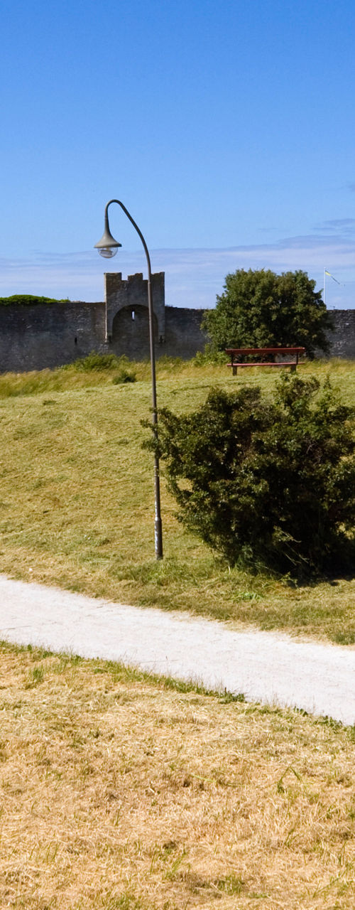 Cyclist on path near historic stone wall