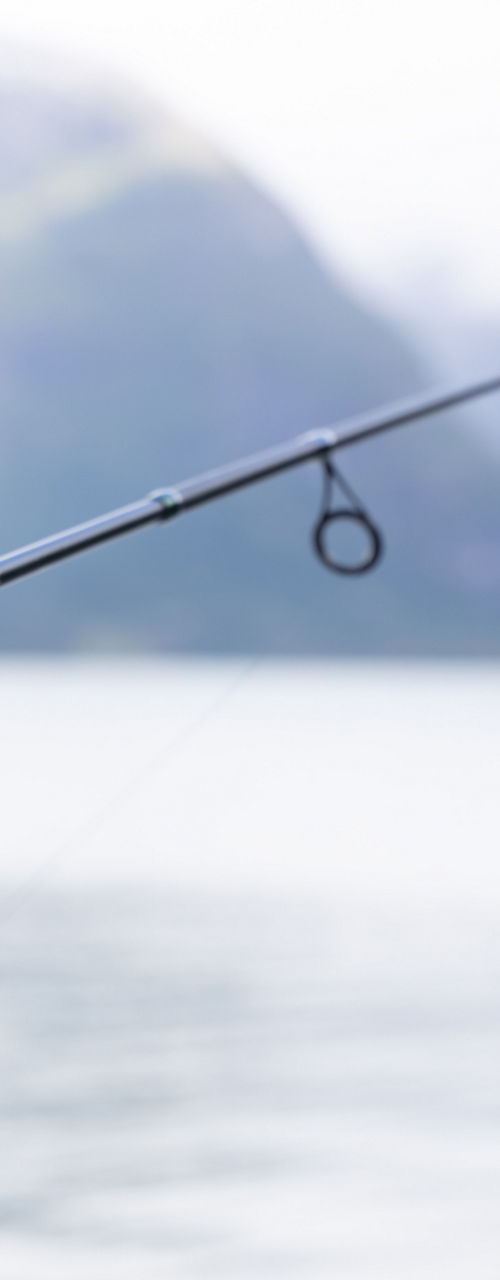 Person fishing in serene mountain lake