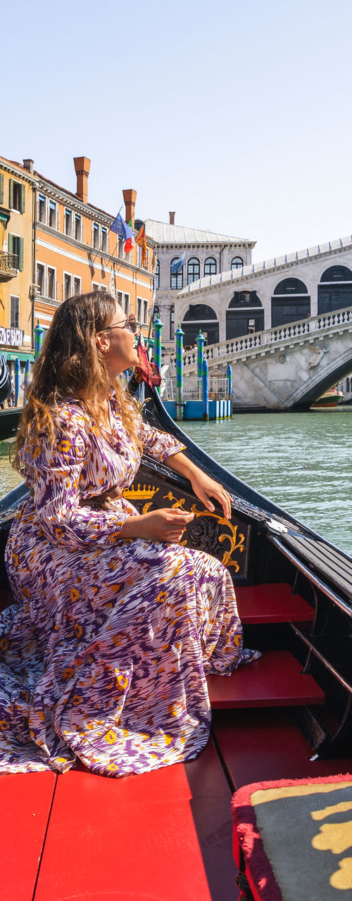 Woman on gondola near Rialto Bridge, Venice