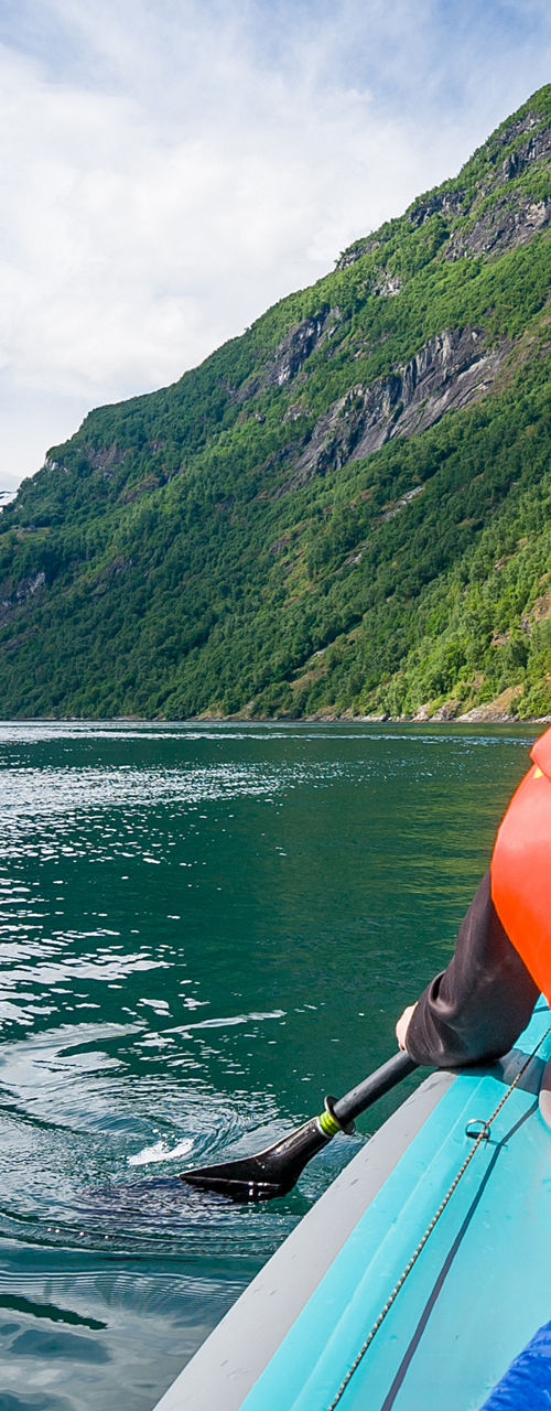 Person kayaking in scenic mountain fjord
