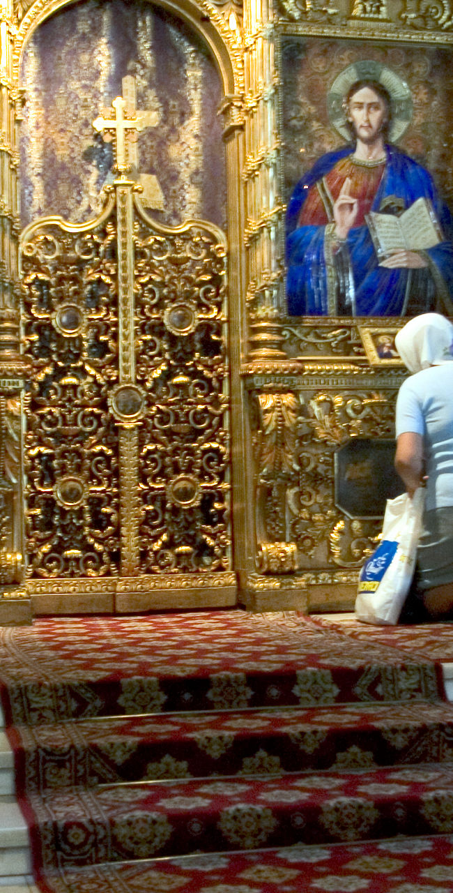 Woman Praying in Ornate Church Interior