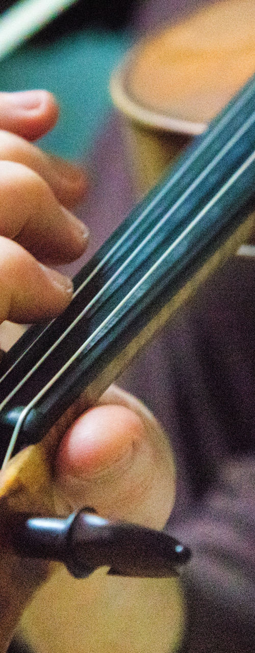 Close-up of violinist playing wooden violin