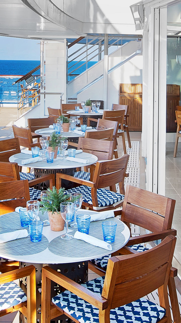 Sunny outdoor cruise ship restaurant with ocean view