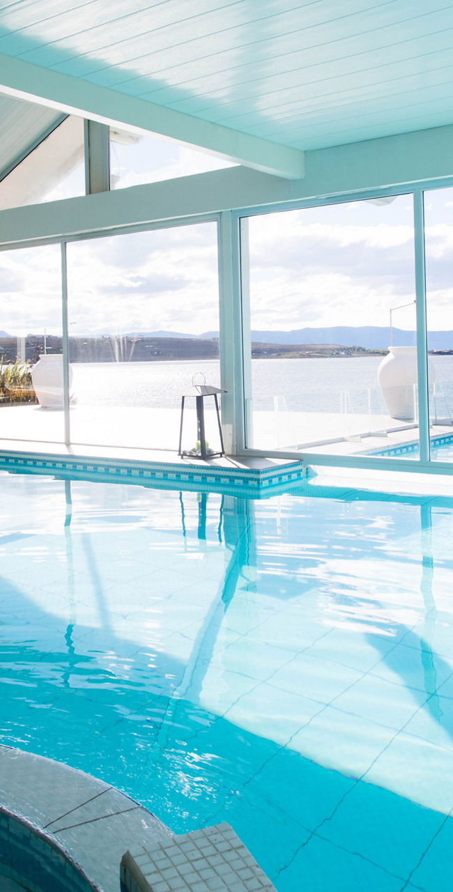 Indoor pool with ocean view and lounge chairs