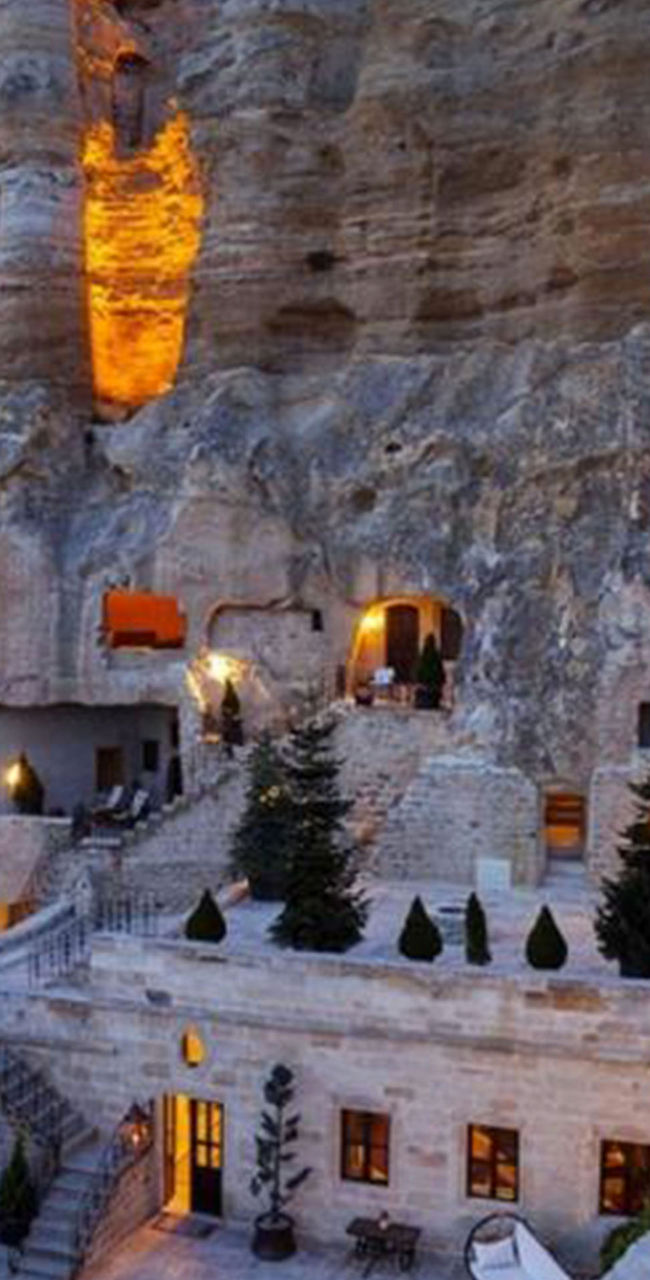 Illuminated cave hotel in rocky landscape