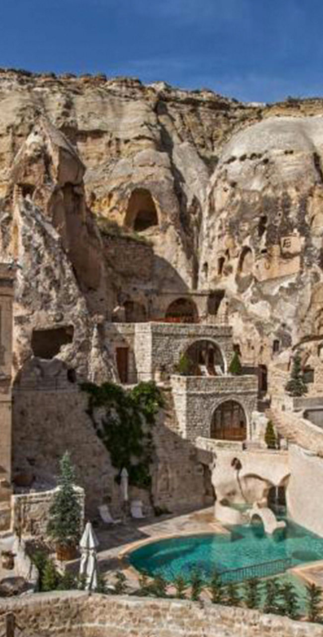 Historic cave hotel with pool in rocky landscape