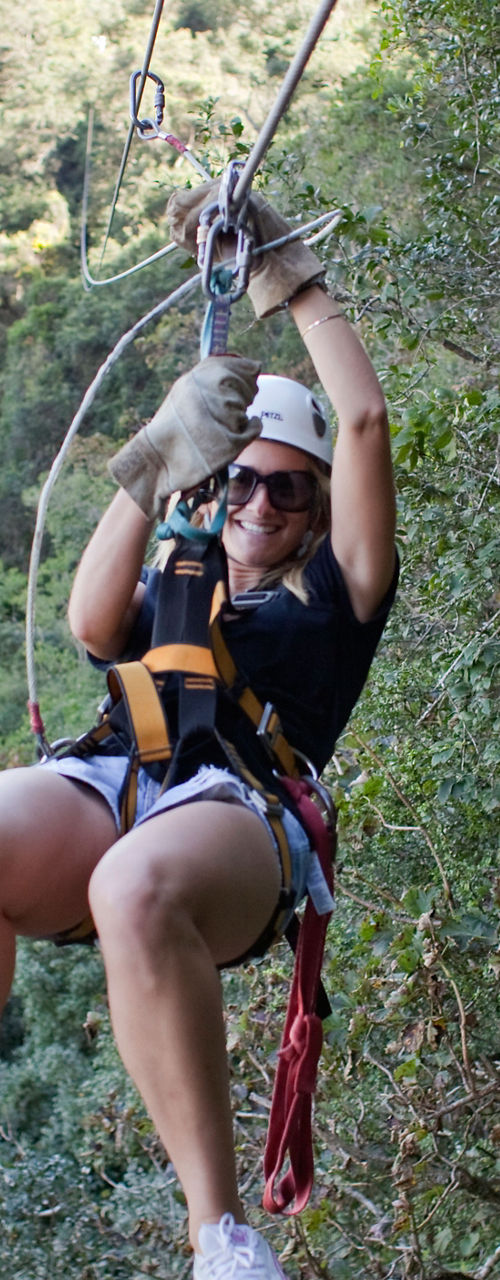 Woman ziplining through forested landscape