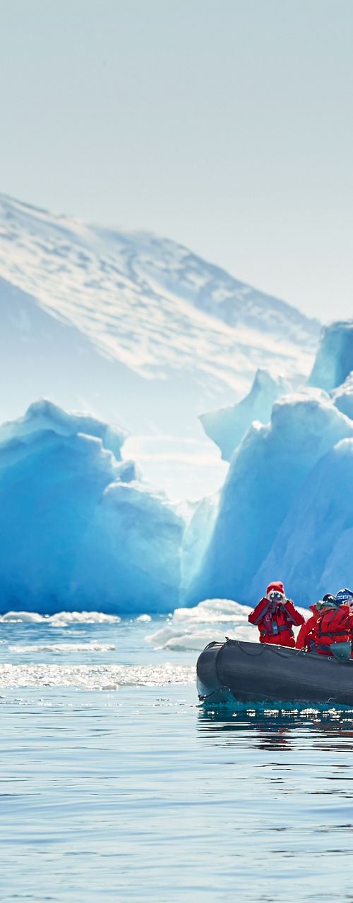 Group exploring icy waters near glacier