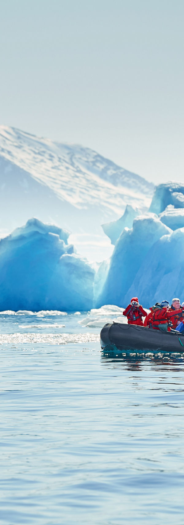 Group exploring icy waters near glacier