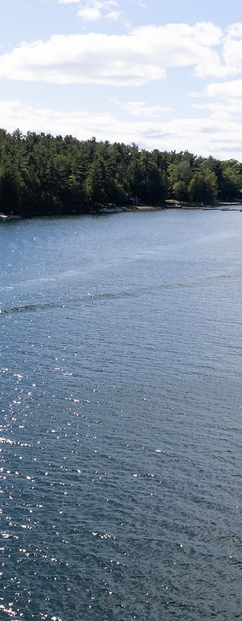 Boats cruising on scenic lake under blue sky