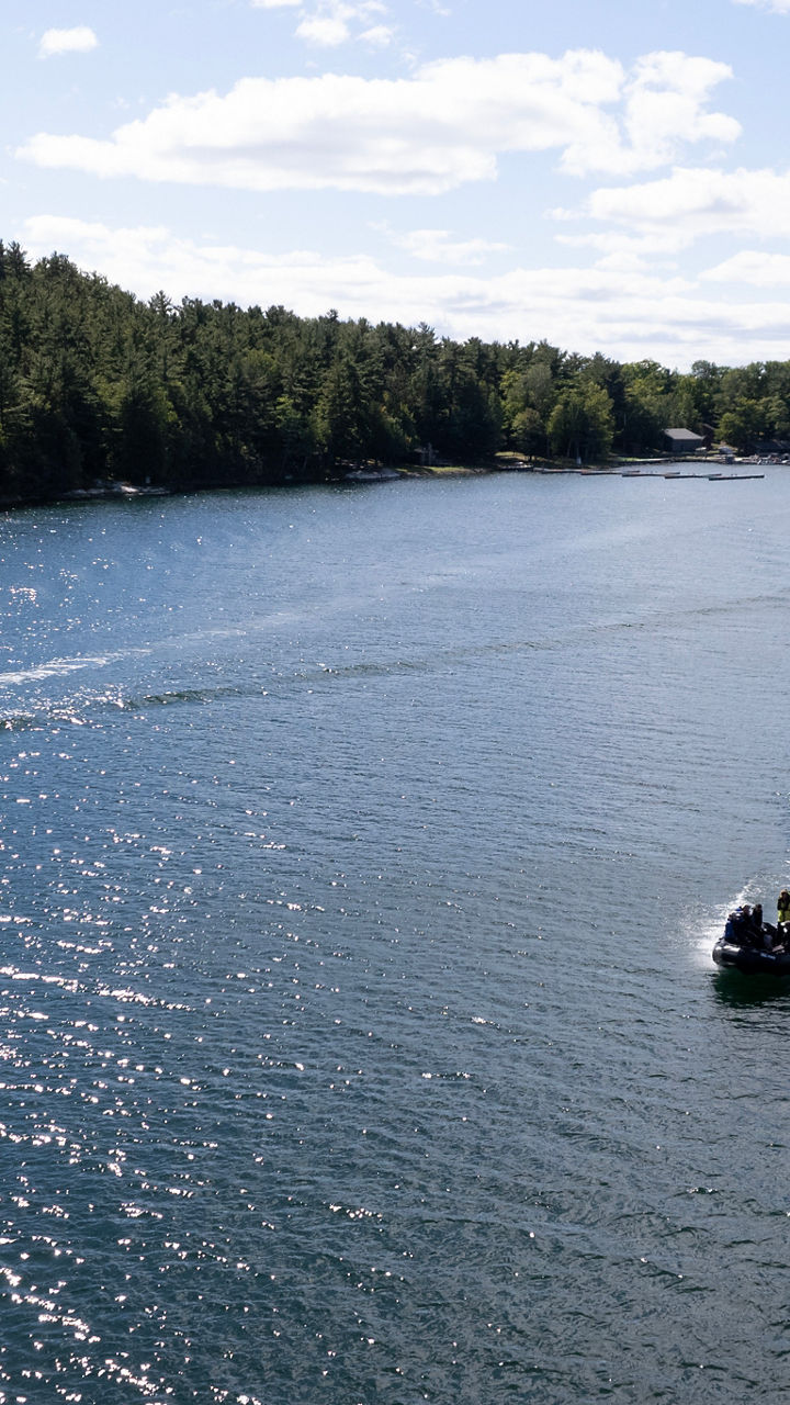 Boats cruising on scenic lake under blue sky