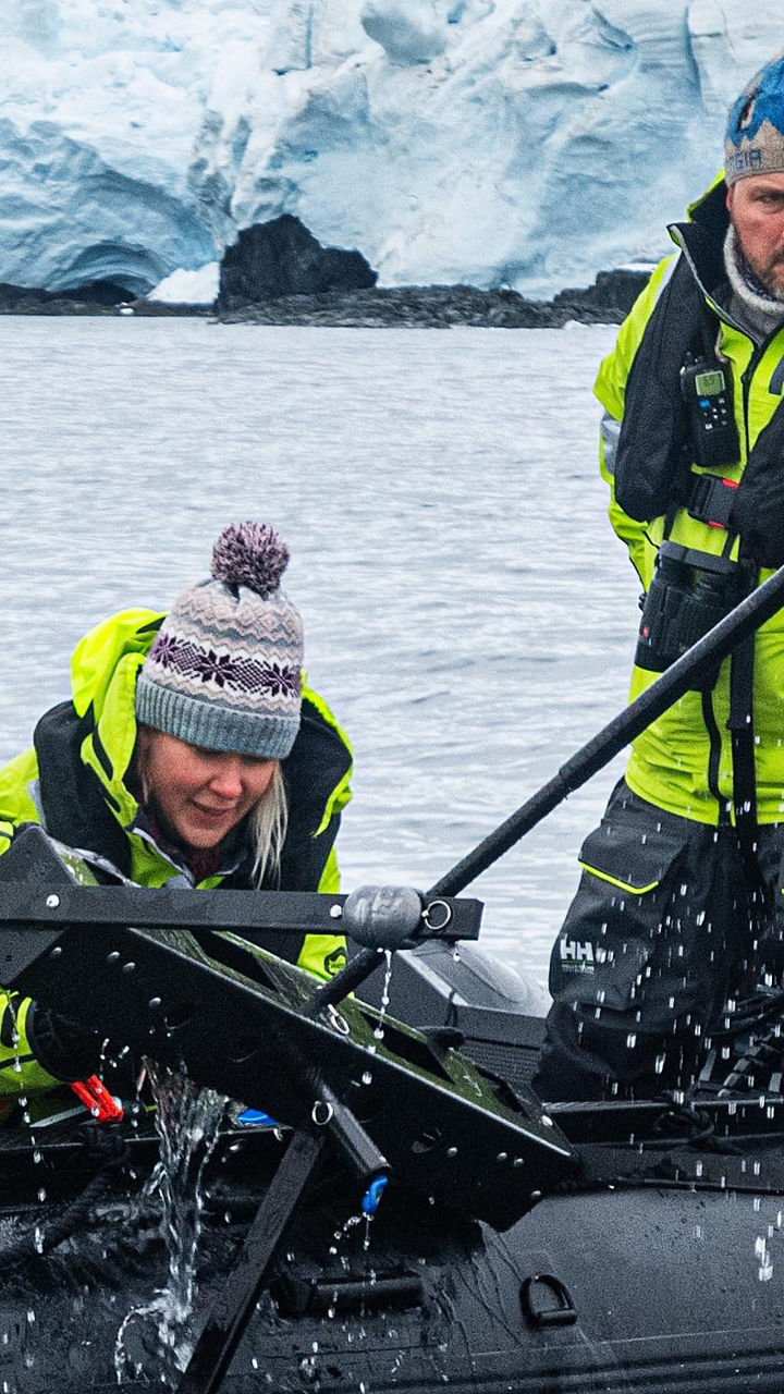 Researchers on inflatable boat in icy waters