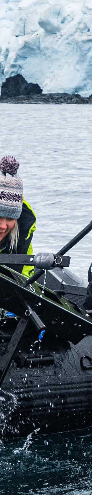 Researchers on inflatable boat in icy waters