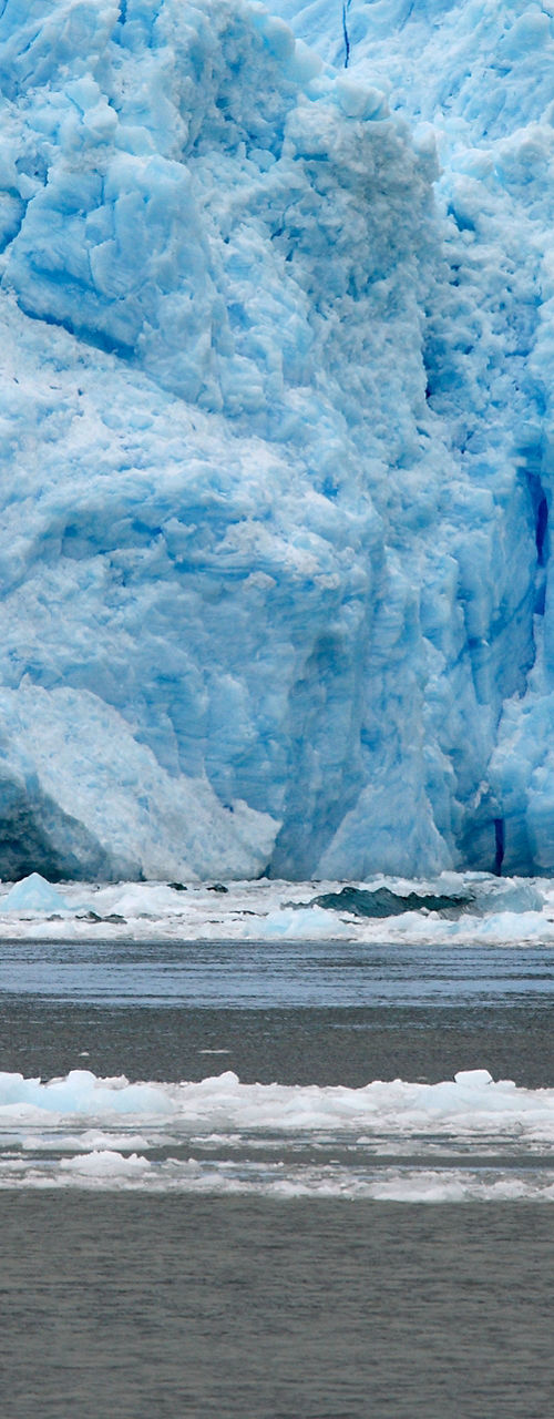 Glacier with small boat in icy waters