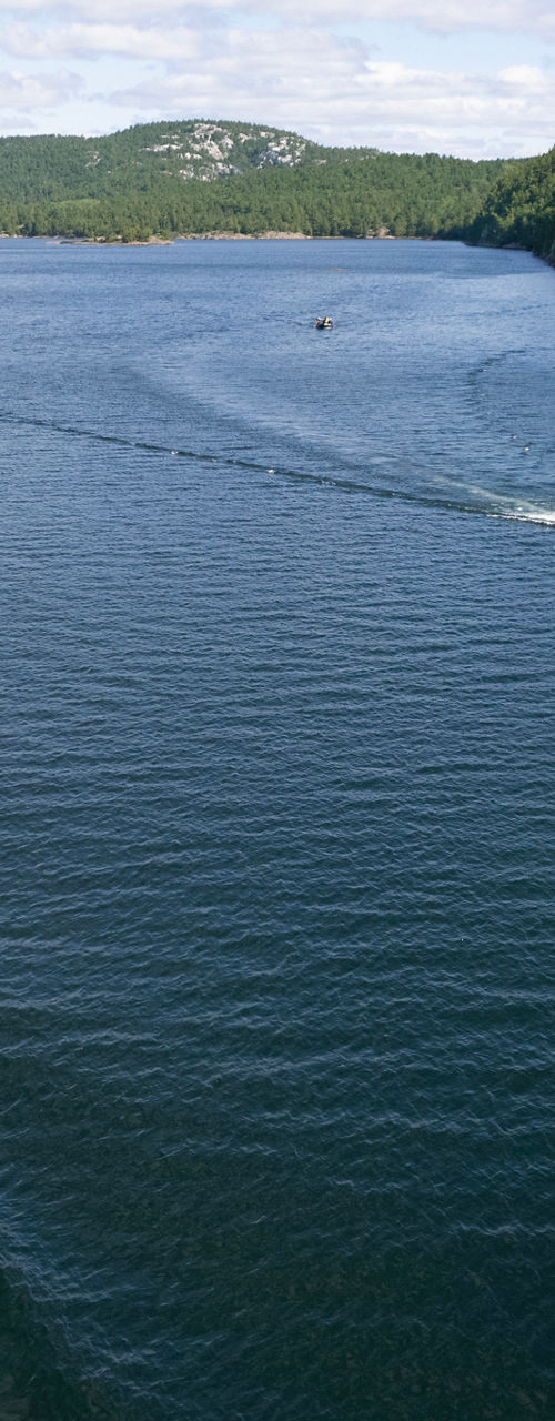 Boats cruising on scenic lake surrounded by forest